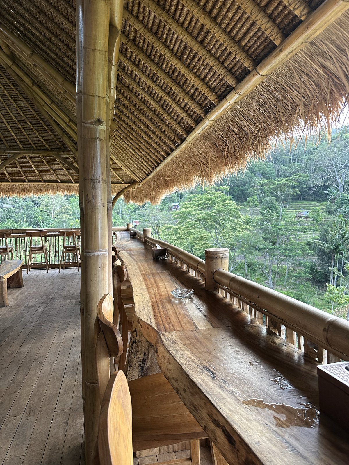 Terrasse en bambou avec comptoir en bois et vue sur la vallée au Uma Ning Cafe, Amed